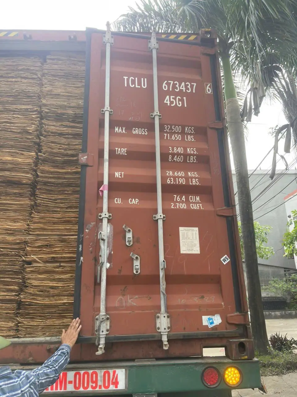 Vietnam plywood export pricing factors — factory floor view of stacked plywood ready for container loading at HCPLY