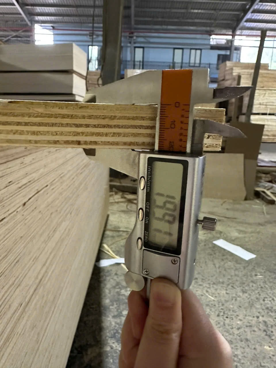 QC inspector measuring plywood thickness with digital caliper at HCPLY Vietnam factory 18mm panel