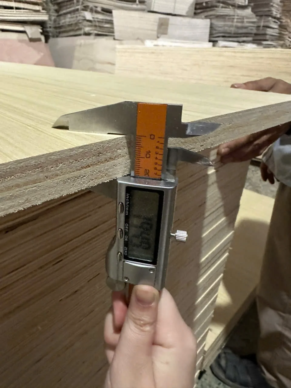 Thickness measurement caliper checking plywood at HCPLY QC station